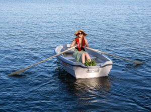 Terhi Sunny, nainen soutaa mökkirannassa.